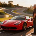 Homme adulte devant une Ferrari rouge sur le circuit de Monza avec la courbe emblématique en arrière-plan