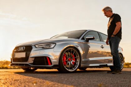Audi A3 8L modifiée avec freins rouges visibles à travers les jantes et carrosserie argentée sous la lumière dorée