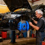BMW E90 Series 3 tuning avec mécanique ajustant le moteur dans un atelier professionnel et calipers bleus vibrants