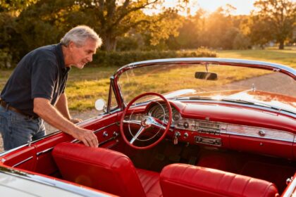 Packard Panther concept car rouge de 1954 avec intérieur en cuir rouge et détails chromés, admiré par un homme âgé