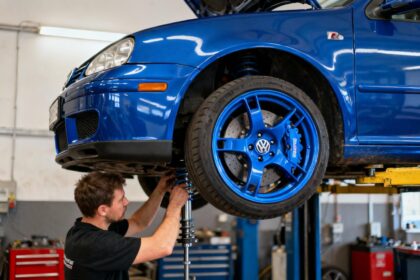 Volkswagen Golf 4 modifiée avec kit carrosserie R32 et jantes custom dans un atelier, mécanicien ajustant la suspension